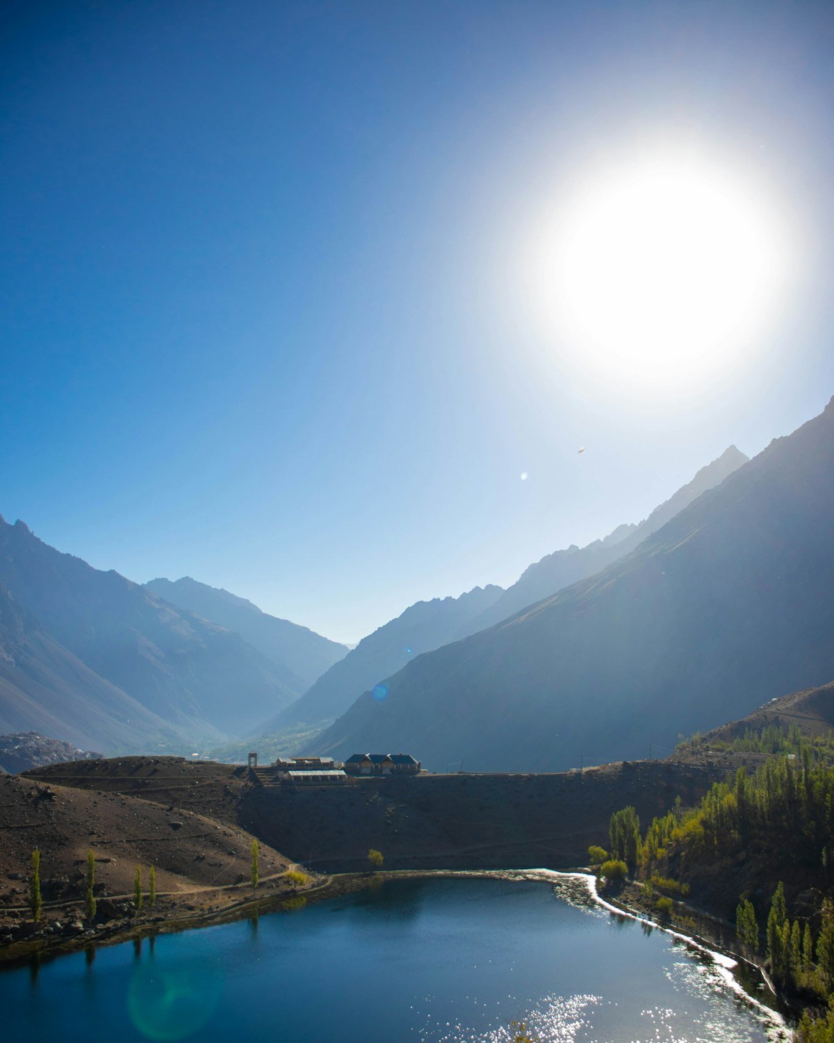 Phander Lake's blue-green water among meadows beneath high mountains